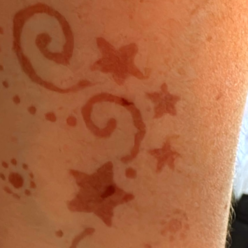 Stars and swirls henna design in warm next-day colour on the arm